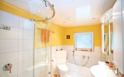 Белоснежный глянцевый потолок в ванную